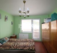 A bedroom in a 4-room apartment with a bed, a wardrobe, and green walls.