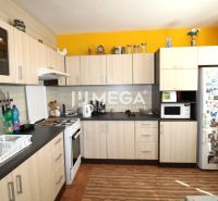 A kitchen in a 4-room apartment with a wood-patterned floor and a yellow wall.