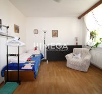 A room in a 4-room apartment with a bed, an armchair, and a floor with a wooden decor.