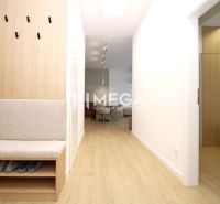 A hallway in a 3-room apartment with a wooden decor floor and built-in seating.