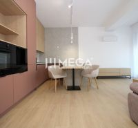 A kitchen in a 3-room apartment with a table, cream chairs, and a floor with a wooden decor.
