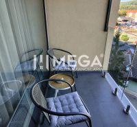 The balcony of a 3-room apartment in Humenné with outdoor seating and a view of the city.