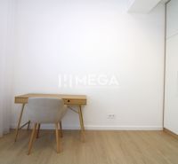 A workspace in a 3-room apartment with a wooden decor floor and white furniture.
