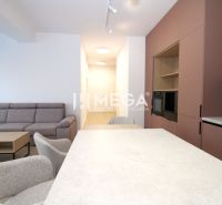 Living area of a 3-room apartment with a comfortable sofa, dining table, and modern kitchen.