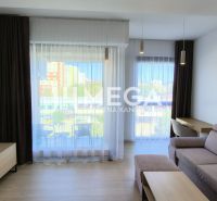 A living room in a three-room apartment with a comfortable sofa and large windows.