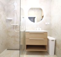 A bathroom with a shower and wooden decor in a 3-room apartment.