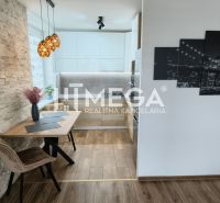 A wall with decorative stone and a kitchen with a wooden decor floor in a 3-room apartment.