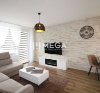 Living room with a light sofa and wood-patterned flooring in a 3-room apartment.
