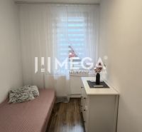 A simple interior of a 3-room apartment with a bed and a floor with a wooden decor.