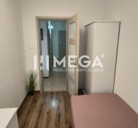 A bright room in a 3-room apartment with a bed, wardrobe, and wooden decor flooring.