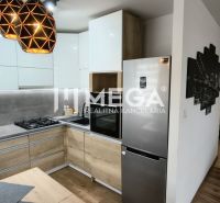 A kitchen in a 3-room apartment with appliances, a wooden decor floor, pendant lights.