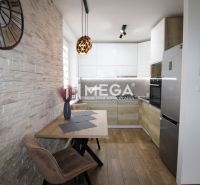 A kitchen in a 3-room apartment with a wooden decor floor and stone cladding.