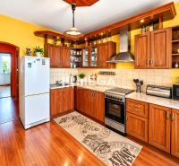 A kitchen with yellow walls, a wooden decor floor in a 4-room apartment.