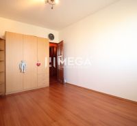 A room in a 4-room apartment with a wooden decor floor and a wardrobe.