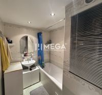 Bathroom in a 4-room apartment with a bathtub, sink, mirror, and window with a blind.