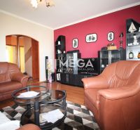 A living room with brown furniture, a red wall, and a floor with a wood pattern in a 4-room apartment.