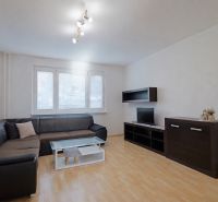 Living room with a black sofa set, cabinets, and a floor with a wood decor, 3-room apartment.