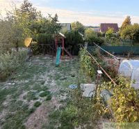 A garden with a lawn and a slide near the cottage in Nové Zámky.