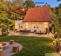 A cottage in Nové Zámky with a terrace, a fire pit, and garden lighting.