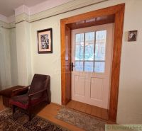 A room in a family house with an armchair, carpet, and glass doors.