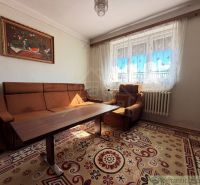Living room in a family house with a brown sofa and curtains.