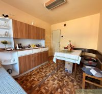 Interior of a family house with a dining table, wooden floor decor, and a classic cabinet.