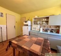 A kitchen in a family house with a wooden decor floor and older furniture.