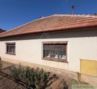 A family house in Hurbanovo with a white facade and a sloped roof on a sunny plot.