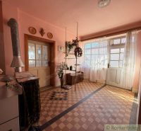 Interior of a family house with pink walls, tiled floor, and double doors.