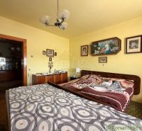 Bedroom in a family house with decorative blankets and wall paintings.