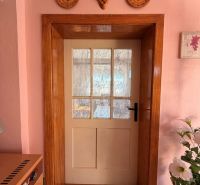 Interior of a family house with doors, embroidered curtains, and rustic decor.