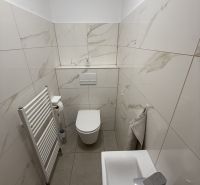 Bathroom in a family house with white tiles and a sink.