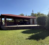 A family house in Zlaté Moravce with a gazebo surrounded by a well-maintained lawn and trees.
