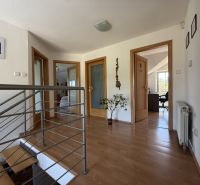 A hallway with a staircase and a wooden decor floor in a family house.