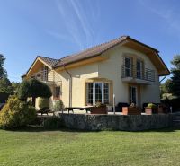 A family house in Zlaté Moravce, surrounded by greenery, with a stone terrace and a balcony.