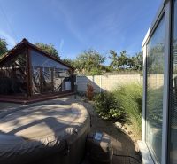 The garden of a family house in Zlaté Moravce with a hot tub and a wooden gazebo.