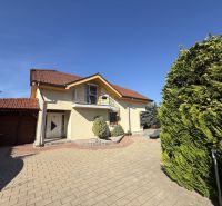 A family house in Zlaté Moravce with a driveway, a balcony, and green trees.