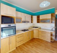 A kitchen with wooden decor and a turquoise wall in a 3-room apartment.