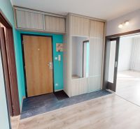 The entrance hall of a 3-room apartment with a wooden decor floor and a built-in wardrobe.