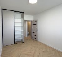 A room in a 4-room apartment with a wood-decor floor and a built-in wardrobe.