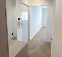 A hallway with a mirror and a wooden decor floor in a 4-room apartment.