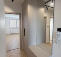 A hallway in a 4-room apartment with integrated storage space and a floor with a wooden decor.