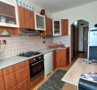 A kitchen in a 3-room apartment with a wooden decor floor and a kitchen unit.
