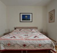 A bedroom in a 3-room apartment with a patterned bedspread and decorations on the walls.