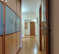 A hallway in a 3-room apartment with wooden decoration and a built-in wardrobe.