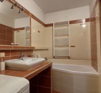 Bathroom in a 3-room apartment with a bathtub and a sink, complemented by ceramic tiles.