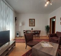 Living room in a 3-room apartment with a wooden decor floor and comfortable furniture.
