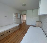 A bedroom in a 3-room apartment with a wooden decor floor, two beds, and a built-in wardrobe.