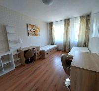 A room with two beds, tables, and a floor with a wooden decor in a 3-room apartment.