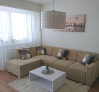 Living room in a 3-room apartment with a corner sofa and a floor with a wooden decor.
